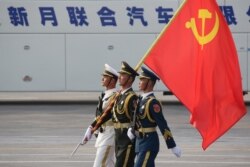 FILE - Soldiers of People's Liberation Army march in formation with a Chinese Communist Party flag during a rehearsal before a military parade marking the 70th founding anniversary of People's Republic of China, in Beijing, China, Oct. 1, 2019.