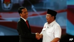 Kandidat presiden Joko Widodo berjabat tangan dengan pesaingnya Prabowo Subianto usai debat capres pertama (15/6).