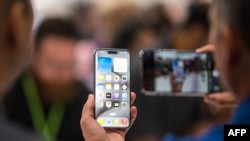 Seorang pengunjung tampak mengamati seri iPhone 15 Pro dalam acara peluncuran di Apple Park di Cupertino, California, pada 12 September 2023. (AFP/Nic Coury)