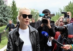 FILE - Yulia Navalnaya, wife of Russian opposition leader Alexei Navalny, speaks with the media outside a hospital, where her husband is receiving medical treatment, in Omsk, Russia, Aug. 21, 2020.
