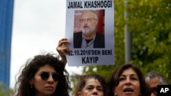 Activists, members of the Human Rights Association Istanbul branch, holding posters with photos of missing Saudi journalist Jamal Khashoggi, talk to members of the media, during a protest in his support near the Saudi Arabia consulate in Istanbul, Oct. 9,