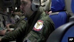 Crew members aboard a French Navy surveillance plane watch monitors showing data and images from radar, cameras and other sensors as it patrols, Jan. 23, 2025, over the Baltic Sea as part of a mission to protect undersea cables and pipelines. 