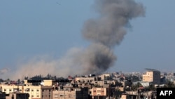 Gambar yang diambil dari Rafah menunjukkan asap mengepul di atas kota Khan Yunis di Jalur Gaza selatan, selama pemboman Israel pada Senin, 4 Maret 2024.