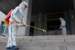Staf Sekolah Dasar Pyongyang No 4 melakukan penyemprotan disinfektan di Pyongyang, Korea Utara, Rabu, 30 Juni 2021.