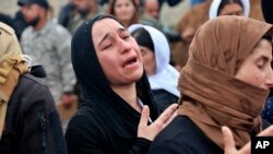 Para perempuan Yazidi Irak menangis saat penggalian sebuah kuburan massal untuk mengidentifikasi jenazah di Sinjar (foto: dok). 