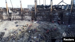 Anggota dari Kementerian Darurat Rusia dan sejumlah pekerja tampak membersihkan puing-puing dari Gedung Crocus yang terbakar menyusul serangan teror yang terjadi di gedung tersebut, di luar Kota Moskow, Rusia, pada 26 Maret 2024. (Foto: Kementerian Darurat/Handout via Reuters)