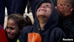 Deca plaču dok ljudi žale za Palestincima ubijenim u izraelskom napadu, u bolnici Naser u Kan Junisu u južnom pojasu Gaze, 5. decembra 2024.