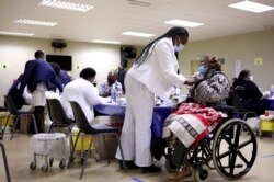 Seorang lansia Afrika Selatan menerima dosis vaksin COVID-19 di Munsieville Care for the Aged Center di luar Johannesburg, Afrika Selatan 17 Mei 2021.(Foto: Reuters)