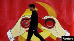 一名男子从上海街头中共党徽前走过。(2019年9月25日)