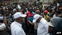 Bakambi ba lingomba Lamuka, Adolphe Muzito (G) na Martin Fayulu (D) na kati ya balandi ba bango na police kopekisa bango kotambola na Knshasa, 30 juin 2019.