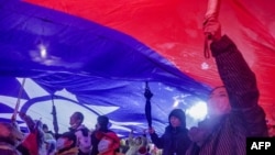 2023年12月23日，在台湾总统选举前的国民党竞选集会上，支持者举起巨大的台湾国旗。