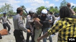 Polisi menangkap seorang warga setelah membubarkan ratusan warga Papua barat yang menghadiri perayaan 50 tahun Kemerdekaan Papua dari penjajahan Belanda di Timika ( 1/12).