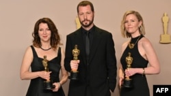 Ukrajinski režiser Mstislav Černov (u sredini), Rejni Aronson-Rat i Mišer Mizner (desno) sa oskarima posle dodjele u Los Aneđelesu (Foto: AFP/Robyn Beck)