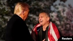 2025년 2월 11일 도널드 트럼프 미국 대통령이 2021년부터 러시아에 억류되어 있던 미국 교사 마크 포겔을 워싱턴 D.C 백악관에서 맞이하고 있다.