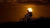FILE - A cyclist tops a hill on a hot day at sunset, Aug. 20, 2023, in San Antonio. Scientists say 2023 will be the warmest in 125,000 years.