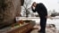 A man bows after leaving flowers at a monument to the victims of political repression in memory of late opposition leader Boris Nemtsov in Saint Petersburg, Russia, on the 10th anniversary of Nemtsov's assassination, Feb. 27, 2025.