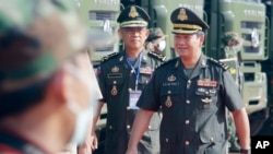 FILE - One of Cambodian Prime Minister Hun Sen's sons, Lt. Gen. Hun Manet, right, arrives for handing over ceremony at National Olympic Stadium in Phnom Penh, Cambodia, Thursday, June 18, 2020. (AP Photo/Heng Sinith) 