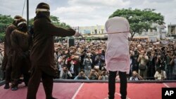 Polisi syariah melakukan hukuman cambuk terhadap seorang pria gay di luar masjid di Banda Aceh, provinsi Aceh, Selasa 