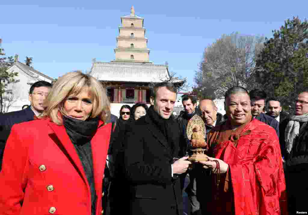 法国总统马克龙和夫人布丽吉特·马克龙(Brigitte Macron)在中国陕西省西安市参观著名的大雁塔,接受礼品(2018年1月8日)。