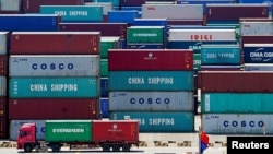 Arhiva: Kamion natovaren kontejnerima snimljen pored kineske zastave u Jangašan luci u Šangaju, Kina, 6. avgusta 2019. (Foto: Rojters, Aly Song)