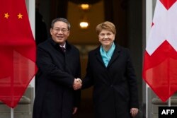 Perdana Menteri China Li Qiang (Kiri) dan Presiden Swiss Viola Amherd berjabat tangan selama kunjungan resmi di Kehrsatz, dekat ibu kota administratif Swiss, Bern pada 15 Januari 2024. (Foto: AFP)