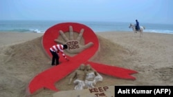 Seniman India menghias pantai Puri dengan hiasan pita merah pada Peringatan Hari AIDS Sedunia dekat Bhubaneswar, India timur (foto: ilustrasi). 