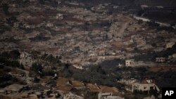 FILE - Bangunan-bangunan yang hancur di wilayah desa Odaisseh, dengan latar belakang Kfar Kila, di Lebanon selatan, yang terletak di sebelah perbatasan Israel-Lebanon, dilihat dari Israel utara, Minggu, 1 Desember 2024. (Leo Correa/AP)