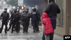 ក្មេង​ស្រី​ម្នាក់ឱប​មនុស្ស​ពេញ​វ័យ​ នៅ​ពេល​ដែល​ប៉ូលិស​បង្ក្រាប​បាតុកម្ម​ឈរ​ត្រៀម​ នៅ​រដ្ឋ​ធានី​វ៉ាស៊ីនតោន នៅ​ពេល​មាន​ការ​បាតុកម្ម​ប្រឆាំង​នឹង​ការ​ស្លាប់​របស់​លោក george floyd​។