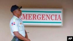FILE - A police officer stands guard outside a hospital in Santo Domingo, Dominican Republic, June 10, 2019. 