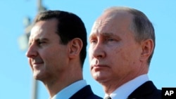 俄罗斯总统普京在叙利亚总统阿萨德陪同下在叙利亚哈迈尼姆航空基地检阅部队。（2017年12月11日）