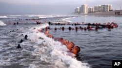 FILE - In this May 4, 2020, photo provided by the U.S. Navy, SEAL candidates participate in "surf immersion" during Basic Underwater Demolition/SEAL training at the Naval Special Warfare Center in Coronado, California.