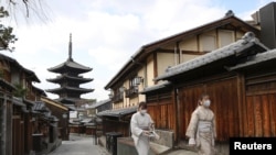 日本京都两名戴着口罩的妇女走过空荡荡的街头。（路透社2021年1月13日）