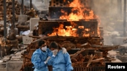 សាច់ញាតិ​របស់​អ្នក​​ស្លាប់​ដោយសារ​ជំងឺ​កូវីដ១៩ យំសោក​ ពេល​គេ​ដុត​សព​ នៅ​ក្នុង​ភូមិ Giddenahalli ក្រុង Bengaluru ប្រទេស​ឥណ្ឌា ថ្ងៃទី១៣ ខែឧសភា ឆ្នាំ២០២១។ 