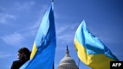 Aktivis mengibarkan bendera Ukraina di luar US Capitol di Washington, DC, pada 23 April 2024. (Foto: AFP)