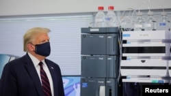 Presiden Donald Trump mengenakan masker saat mengunjungi pabrik farmasi Fujifilm Diosynth Biotechnologies' Innovation Center yang memproduksi komponen kandidat vaksin virus corona, di Morrisville, North Carolina, 27 Juli 2020. (Foto: Reuters)