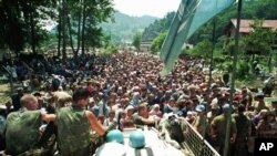 Arhiva - Holandski pripadnici snaga UN sede na bornim kolima okruženi mislimanskim izbeglicama iz Srebrenice, nedaleko od Potočara, u istočnoj Bosni, Bosna i Hercegovina, 13. jula 1995.