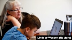Siswa kelas 4 di Cottage Lake Elementary mencoba mencari tahu instruksi penugasan di laptopnya saat pembelajaran online yang diterapkan di Distrik Northshore School selama dua minggu akibat corona, di Woodinville, Washington, AS, 11 Maret. 2020. (Foto: Reuters/Lindsey Wasson)