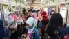 Para penumpang perempuan mengenakan masker di tengah wabah virus corona (Covid-19) di gerbong kereta commuter, di Jakarta, 7 April 2020. (Foto: AFP)