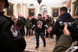A supporter of President Donald Trump confronts police on the second floor of the U.S. Capitol after Trump supporters breached security defenses, in Washington, January 6, 2021.