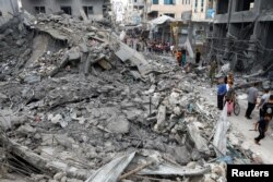 Warga Palestina memeriksa kerusakan pasca serangan Israel, di Khan Younis, Jalur Gaza selatan, 10 Oktober 2023. (Foto: REUTERS/Ibraheem Abu Mustafa)