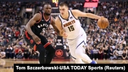 Nikola Jokić u prodoru protiv košarkaša Toronta Serža Ibake na utakmici u "Skošiabenk areni" u Torontu (Foto: Reuters/Tom Szczerbowski-USA TODAY Sports) 