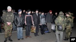 Người Nga, bên phải quay lưng về phía máy chụp hình, và người Ukraine chuẩn bị trao đổi tù binh bên ngoài Donetsk ở miền đông Ukraine, ngày 26 tháng 12, 2014.