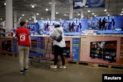 한 여성이 미국 브랜드인 코스트코 매장에서 전자제품을 바라보고 있다.