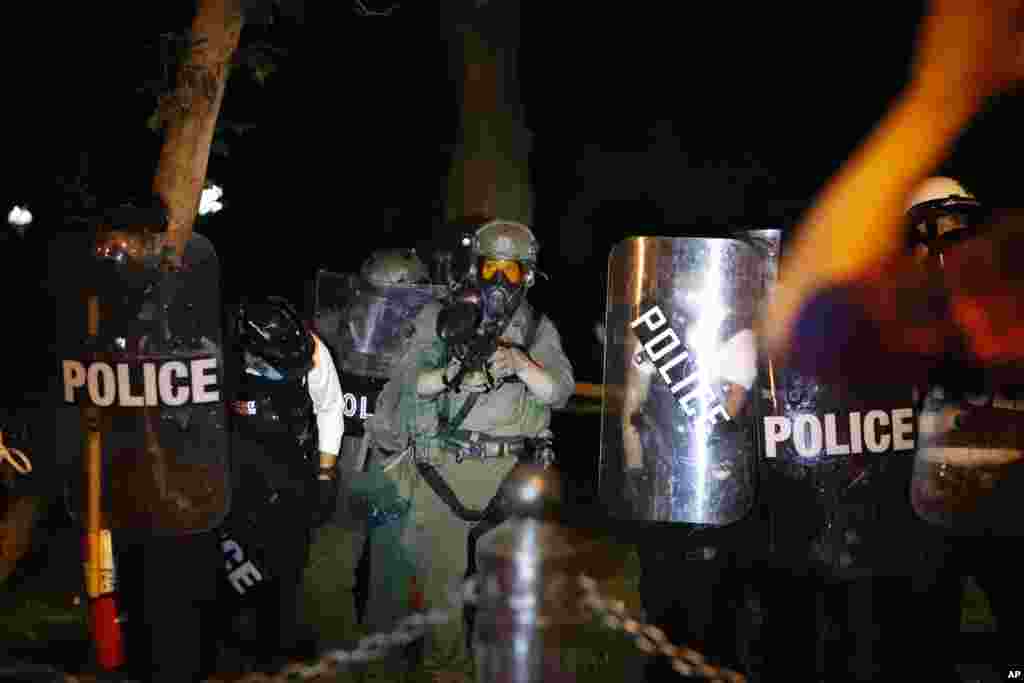 ប៉ូលិស​ប្រដាប់​ដោយ​ឧបករណ៍​ទប់ទល់​នឹង​កុប្បកម្ម ឃ្លាំមើល​កុប្បកម្ម​ខណៈ​ក្រុមបាតុករ​ប្រមូល​ផ្តុំគ្នា ដើម្បី​តវ៉ា​អំពី​ការស្លាប់​របស់​លោក George Floyd នៅ​ថ្ងៃសៅរ៍​ទី ៣០ ខែឧសភា ឆ្នាំ ២០២០ ក្បែរ​សេតវិមាន​ក្នុង​រដ្ឋធានី​វ៉ាស៊ីនតោន។ លោក Floyd បាន​ស្លាប់ បន្ទាប់ពី​ត្រូវបាន​ឃាត់ខ្លួន​ដោយ​ប៉ូលិស​នៅ​ទីក្រុង Minneapolis រដ្ឋមីនីសូតា សហរដ្ឋ​អាមេរិក កាលពី​ថ្ងៃចន្ទ ទី ២៥ ខែឧសភា ឆ្នាំ២០២០។ (AP) 