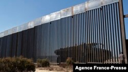 Arhiva - Žena gleda kroz deo zida na granici SAD i Meksika, u istočnoj Tekati, Meksiko, 7. oktobra 2020.