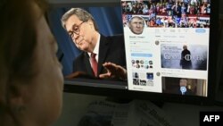 A photo illustration dated April 18, 2019 in Washington, D.C. shows an editor looking at a photograph of U.S. Attorney General William Barr (L) speaking about the release of the redacted version of the Mueller report, juxtaposed with U.S. President Donald Trump's Twitter feed.