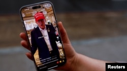A woman shows her smartphone, displaying the @realdonaldtrump TikTok page, in Washington, Jan. 19, 2025.