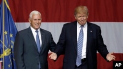 Gubernur Indiana, Mike Pence, bersama kandidat presiden AS dari Partai Republik, Donald Trump, dalam sebuah kampanye di Westfield, Indiana (12/7). (AP/Michael Conroy) 