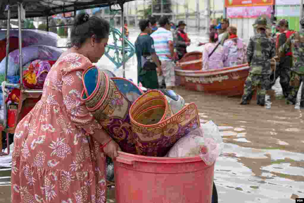ស្ត្រីមានផ្ទៃពោះម្នាក់កំពុងជម្លៀសរបស់របរផ្ទាល់ខ្លួនចេញពីតំបន់ទឹកជន់លិចទៅកាន់តំបន់ដីទួល នៅភូមិព្រែកជ្រៃ សង្កាត់ស្ពានថ្ម ខណ្ឌដង្កោរ រាជធានីភ្នំពេញ ថ្ងៃទី១៥ ខែតុលា ឆ្នាំ២០២០។ (ទុំ ម្លិះ/វីអូអេ)