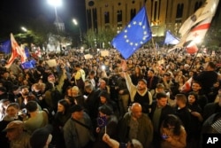 ARHIVA - Demonstranti mašu zastavama EU i Gruzije ispred zgrade parlamenta u Tbilisju, 15. aprila 2024. (Foto: AP/Zurab Tsertsvadze)